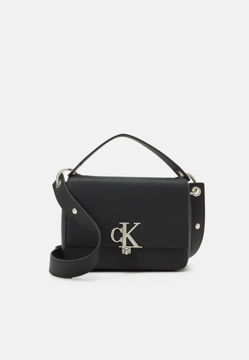 Black handbag made of textured material, featuring a silver "CK" logo, a top handle, and a detachable shoulder strap.