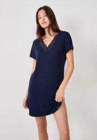 Abito blu navy a maniche corte con inserto di pizzo ondulato sullo scollo a V, realizzato in tessuto morbido e liscio con una vestibilità rilassata.