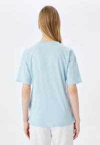 Lichtblauwe katoenen t-shirt met korte mouwen en een ronde hals, met een relaxte pasvorm en een gladde textuur. Geen zichtbare patronen of hardware.