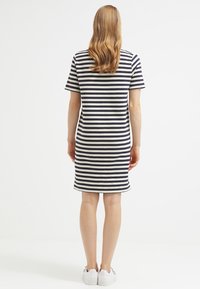 Abito a maniche corte a righe di colore blu navy e crema, lungo fino al ginocchio, con una vestibilità comoda. Realizzato in morbido cotone, presenta un colletto rotondo e un orlo dritto.