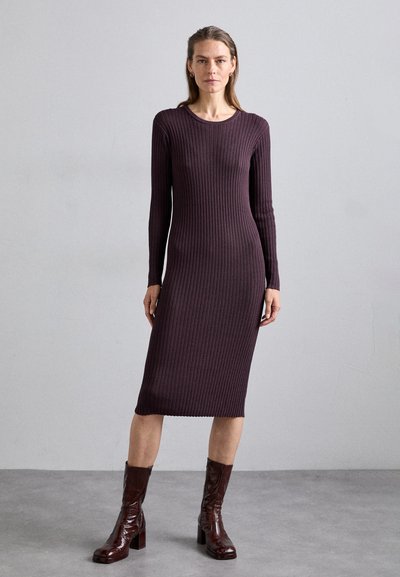 Rochie ribbed, cu mânecă lungă, de culoare vișinie, cu un guler rotund și tiv până la genunchi. Purtați cu cizme lucioase maro până la genunchi. Textură netedă.