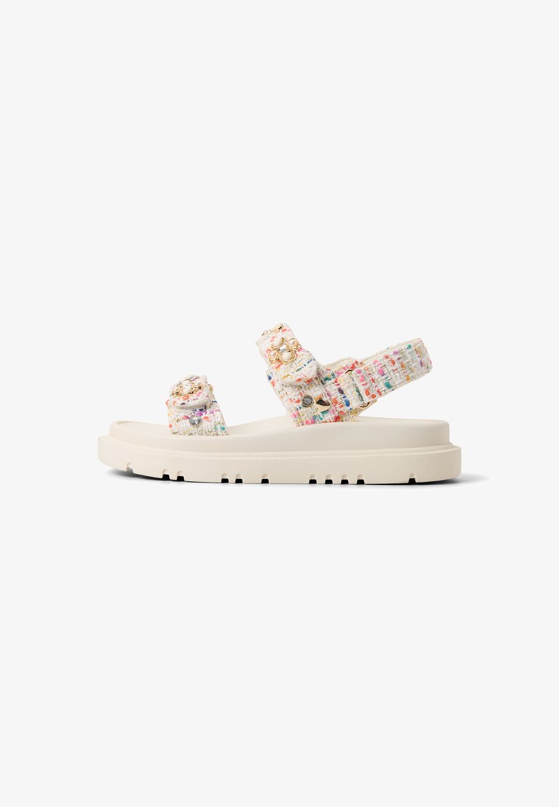 Chunky sandals with a textured, multicolored fabric upper and cream rubber sole. Adjustable straps feature decorative accents.
