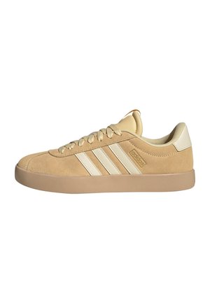 Sneaker Adidas in suede beige con suola in gomma beige, tre strisce crema sul lato e lacci beige.