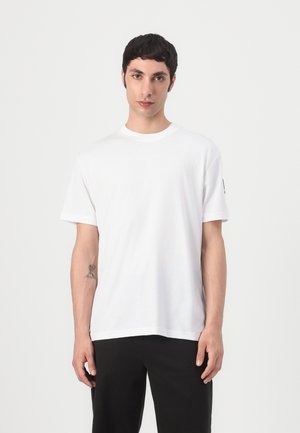 Witte korte mouw t-shirt van katoen met een ronde hals. Heeft een eenvoudige uitstraling en een subtiele logo-accent op de mouw.