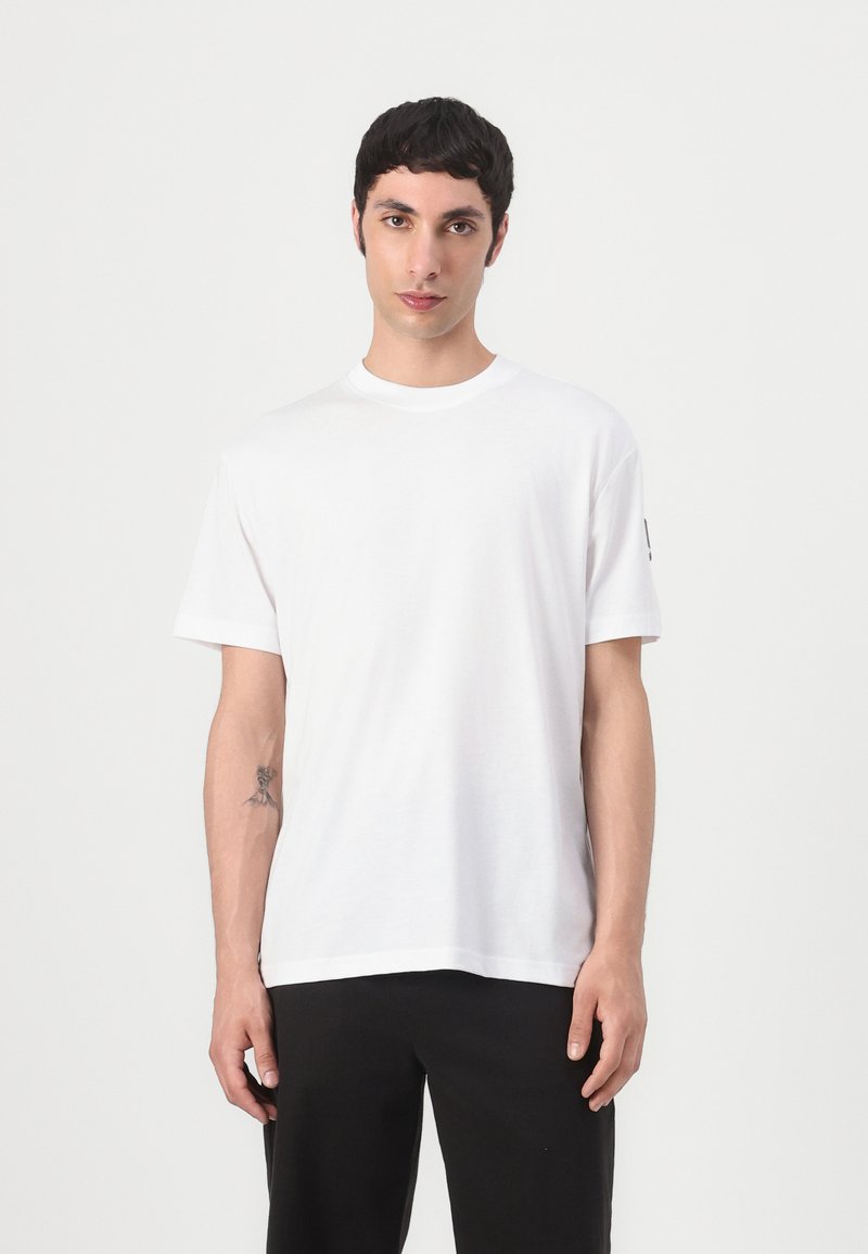 Witte korte mouw t-shirt van katoen met een ronde hals. Heeft een eenvoudige uitstraling en een subtiele logo-accent op de mouw.