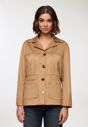 Giacca in suede tan con dettagli in frange sul petto. Presenta un colletto, due tasche frontali e grandi bottoni. Maniche lunghe.