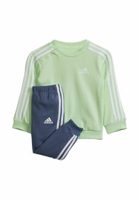 Felpa verde chiaro con righe bianche, dotata di bottoni a pressione e un piccolo logo. Pantaloni blu scuro con righe bianche e cintura elastica.