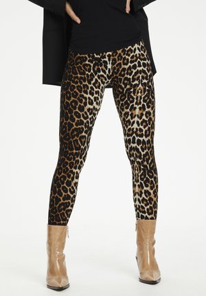 Leopard print leggings with a fitted, stretchy design in shades of black, brown, and cream; worn with beige ankle boots.