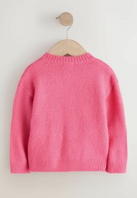 Pull rose tricoté avec un col rond, des poignets et un ourlet côtelés. Texture douce, suspendu à un cintre en bois sur un fond uni.