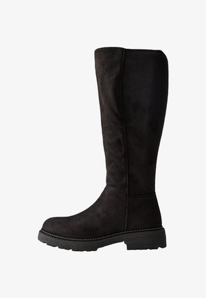 Czarne zamszowe botki za kolano z okrągłym noskiem, grubą gumową podeszwą i minimalnymi detalami szwów. Teksturowana cholewka gładko przechodzi w łydkę.