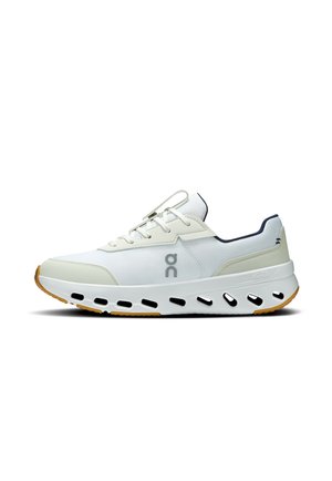 Weißer und beiger Sportschuh mit schwarzem Logo, Schnürsenkeln vorne und weißer Sohle mit mehreren ovalen Ausschnitten.