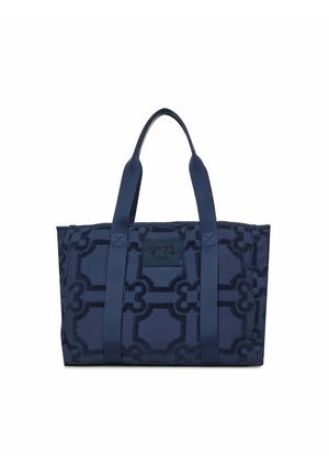 Sac cabas bleu marine avec motif géométrique, deux longues poignées, et une étiquette carrée portant l'inscription "V°73 Venezia" au centre avant.