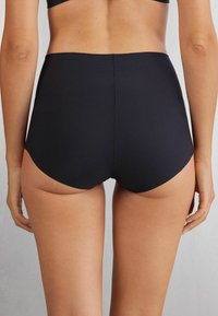 Zwarte bikini bottom met hoge taille, gemaakt van rekbaar materiaal, met een gladde textuur en een minimalistisch ontwerp zonder naden.
