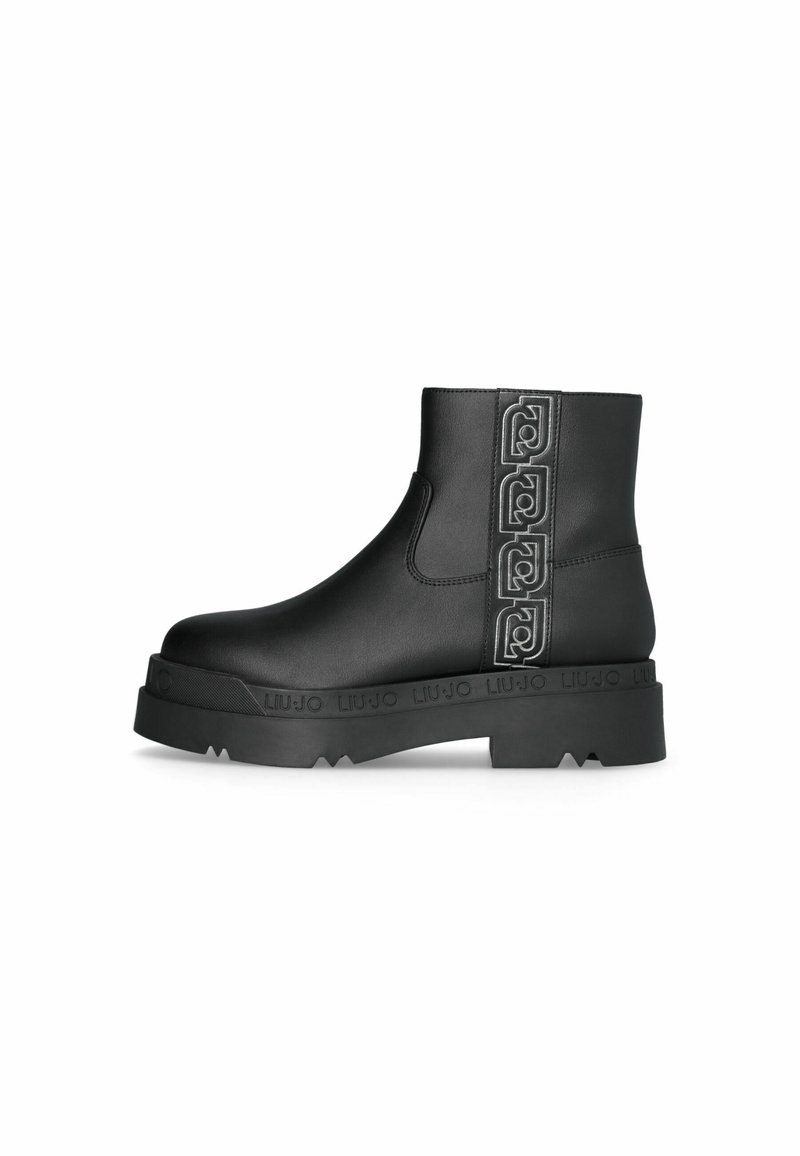 Bottine en cuir noir avec semelle épaisse, logos décoratifs cousus sur le panneau latéral et semelle extérieure texturée.