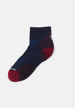 Dark blue and burgundy ankle sock featuring geometric patterns, textured stripes, and red toe accents. Made from a soft, stretchy fabric.