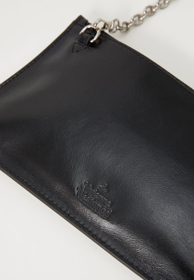 Geantă de mână din piele neagră cu o textură netedă, dotată cu o curea din lanț argintiu și un logo al brandului embosat. Formă rectangulară cu un design minimalist.