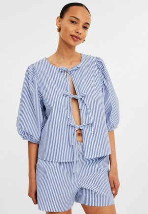 Blauw-wit gestreepte top met korte mouwen en een ronde halslijn, heeft vooraan strikjes en is gecombineerd met bijpassende shorts, wat zorgt voor een ontspannen fit.
