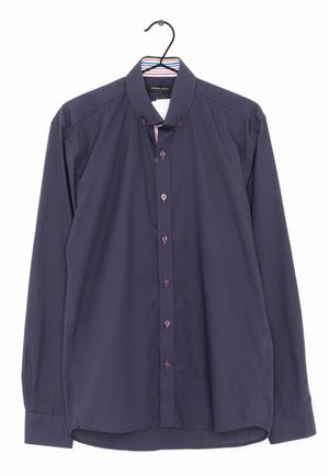 Camicia a maniche lunghe blu navy con colletto strutturato, caratterizzata da dettagli con bottoni rossi e un motivo a righe all'interno del colletto.