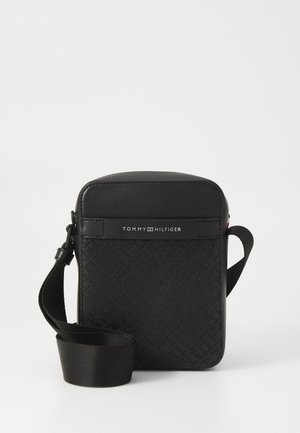 Čierna syntetická crossbody taška s textúrovaným vzorom, detailom loga na prednej strane a nastaviteľným popruhom. Obdĺžnikový tvar s hladkými akcentmi.