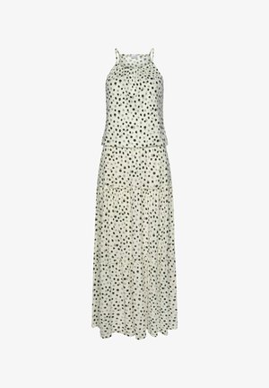 Sleeveless, light-colored dress with black polka dots, a gathered neckline, and a flowing skirt featuring a ruffled hem.