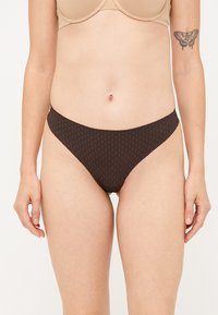 Hnedé vzorované bikiny s nízkym pásom, s hladkou textúrou a elastickým pásom, vhodné na plávanie.