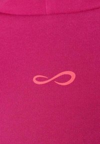 Primer plano de una tela rosa con un pequeño símbolo de infinito en color rosa claro impreso en ella.