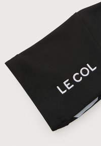 Black athletic sleeve with embroidered "LE COL" logo. Material is smooth, stretchy, with a fitted design and clean seams.