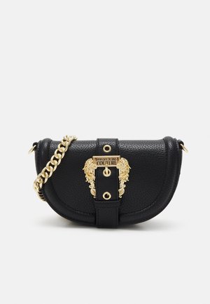 Czarna, teksturowana skórzana torebka crossbody w kształcie półksiężyca z złotym łańcuszkowym paskiem i ozdobną złotą klamrą z wygrawerowanym napisem "Versace Jeans Couture."