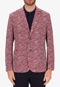 Blazer houndstooth rosso e bianco, design a monopetto con rever a punta, due tasche frontali e due bottoni. Tessuto a trama intrecciata.