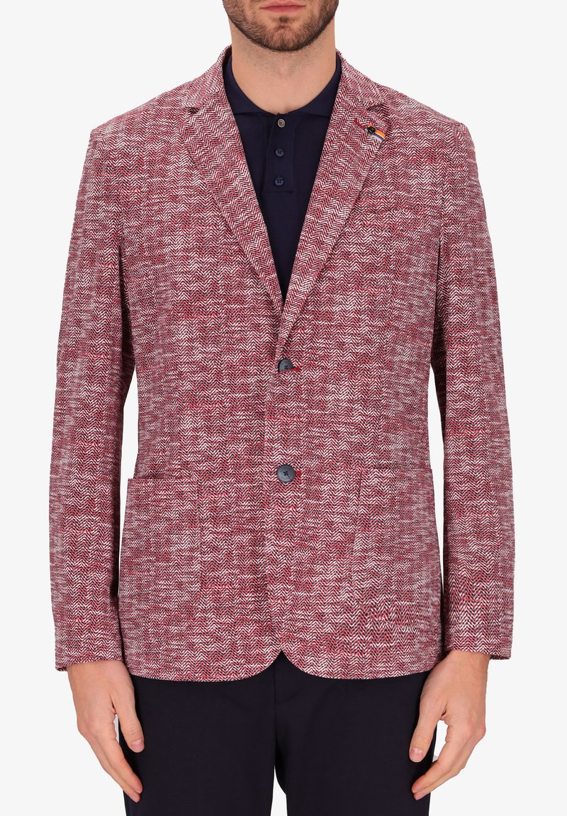 Blazer houndstooth rosso e bianco, design a monopetto con rever a punta, due tasche frontali e due bottoni. Tessuto a trama intrecciata.