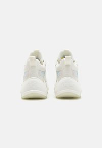 Zapatillas blancas con parte superior de cuero suave, paneles de malla y suela texturizada. Presenta un panel reflectante y un logotipo en relieve en el talón.