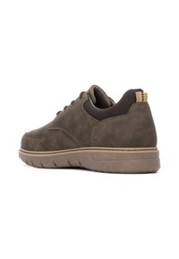 Zapatillas de ante marrón con un cuello de tejido texturizado, suela flexible y acentos en beige contrastantes en el talón y los cordones.