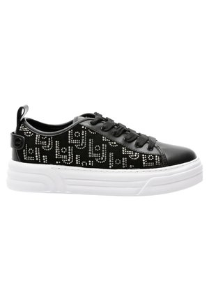 Sneakers neri con tomaia in pelle liscia e tessuto testurizzato. Presentano una suola in gomma bianca e borchie decorative argentate che formano un motivo.