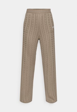 Pantaloni beige a vita alta in maglia a treccia con gambe larghe. Presentano una vita a coste e un motivo testurizzato su tutta la stoffa.