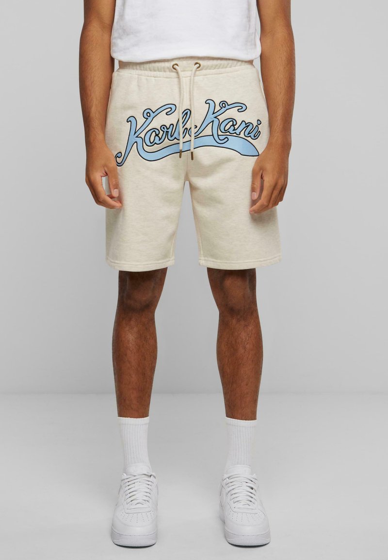 Shorts de jogging en coton beige avec une taille élastique, une fermeture à cordon, et un logo graphique bleu sur le devant. Comprend des poches latérales.