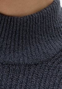 Dunkelgrauer, gerippter Sweaterstoff mit einem hohen, strukturierten Kragen. Gestricktes Muster mit weichem, flauschigem Aussehen und enger Maschenstruktur.