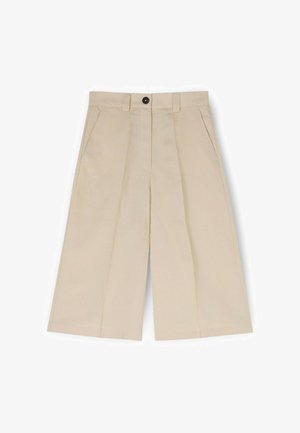 Beige vidde-cropped bukser med forreste læg, sidelommer, bæltestropper og sort knaplukning i taljen.