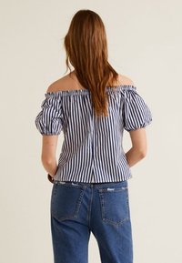 Haut épaules dénudées avec manches bouffantes, présentant des rayures verticales bleues et blanches. Vue de dos montrant un encolure élastique et une silhouette ajustée.