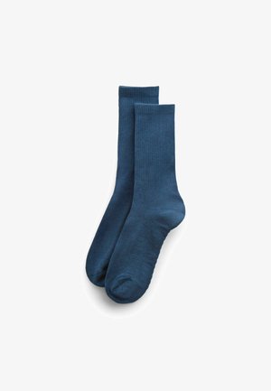 Paar schlichter dunkelblauer Mid-Calf-Socken mit gerippten Bündchen, flach auf weißem Hintergrund ausgelegt.