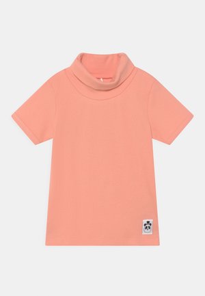 Kortærmet ferskenfarvet rullekrave-shirt med ribbet tekstur og en lille panda logo-tag ved nederste højre kant.