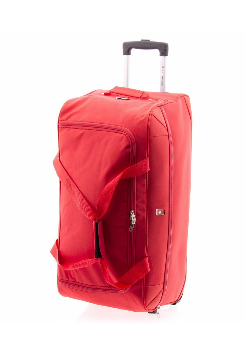 Valise à roulettes rouge avec un extérieur souple, deux poignées, une fermeture à glissière unique et des coins renforcés. Forme rectangulaire compacte.