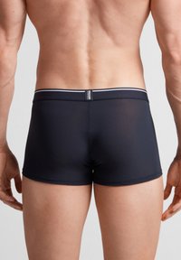 Mörkblå boxershorts med en åtsittande passform, försedd med en kontrasterande vit midjeband och smidig, elastisk tyg. Texturerad look förstärker designen.