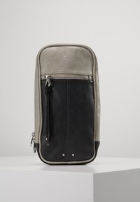 Skórzany plecak z szarym wierzchem i czarną dolną częścią, wyposażony w przednią kieszeń na zamek błyskawiczny, srebrne akcesoria i zaokrąglone krawędzie.