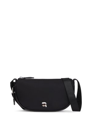 Sac bandoulière noir en nylon avec une texture lisse, fermeture zippée et bandoulière réglable. Présente un petit logo sur le devant.