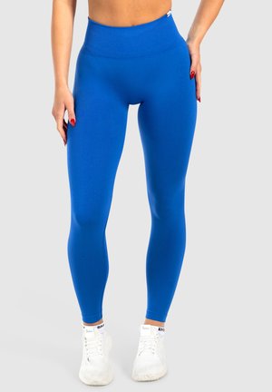 Hooggewaisted blauwe leggings van rekbaar, glad materiaal. Heeft een geribbelde tailleband en een strakke, figuurvolgende pasvorm.