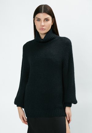 Maglione nero a collo alto in maglia con maniche ampia, orlo a costine e motivo testurizzato. Realizzato in un morbido e spesso materiale misto lana.