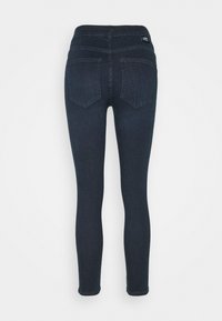 Jeans de mezclilla de lavado oscuro con corte slim, que cuentan con una cintura alta, dos bolsillos traseros y detalles de costura mínimos.