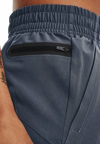 Dark gray athletic shorts with a textured surface, elastic waistband, and a zippered pocket on the side. Features angled stitching details.