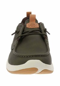 Scarpa da barca verde in pelle con accenti marroni, punta arrotondata e suola bianca. Presenta un'etichetta con il logo "Hey Dude" sulla linguetta e lacci elastici.