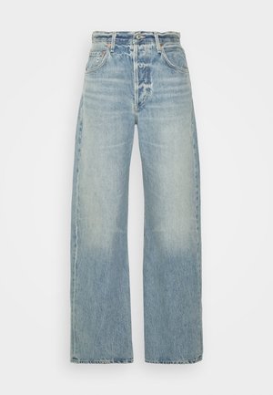 Jeans en denim bleu clair avec une coupe évasée, dotés d'une taille haute, de cinq poches et d'un léger délavage, affichant une finition texturée classique.